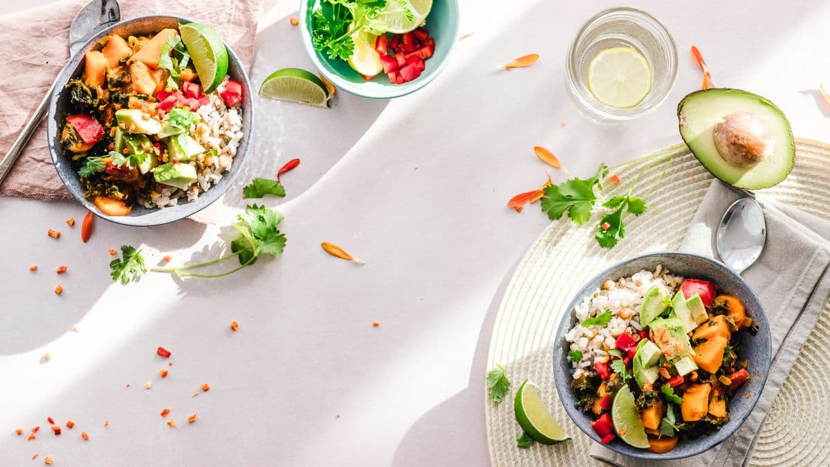 Bowls de comida saludable con verduras, arroz y aguacate vistos desde arriba