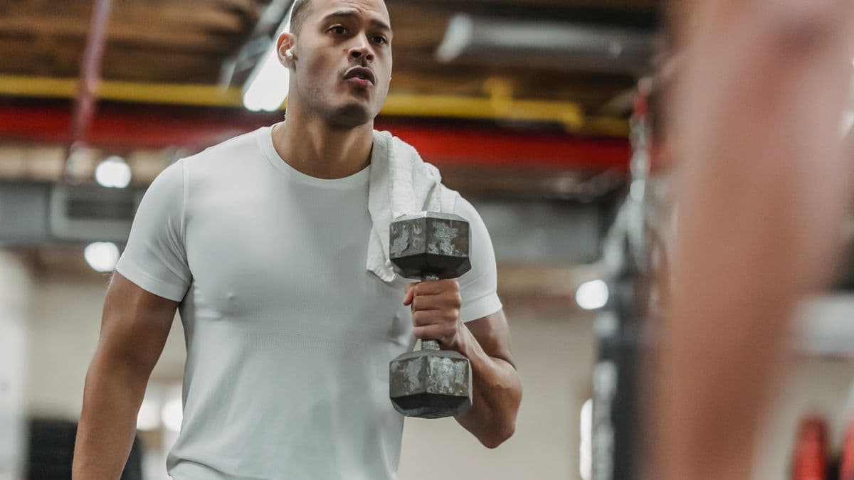 Persona entrenando con una mancuerna en el gimnasio