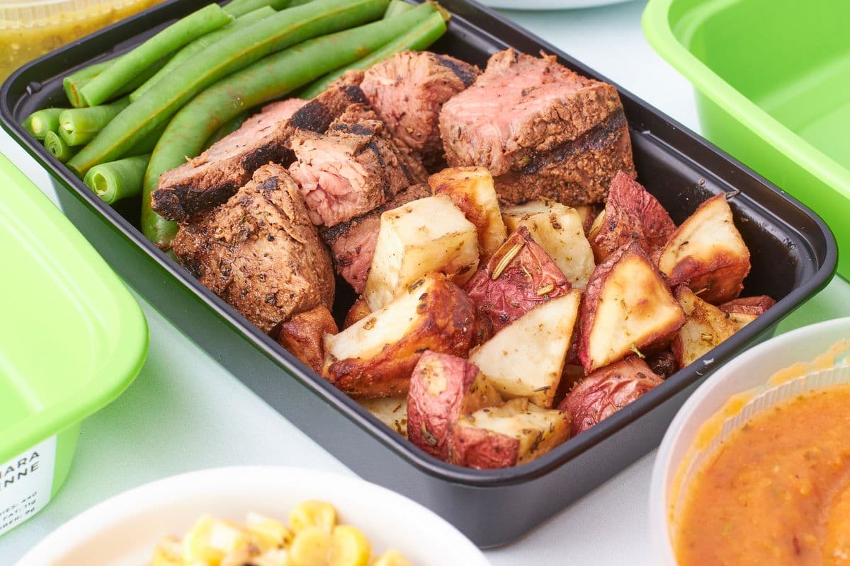 Plato de meal prep con carne, judías verdes y patata asada